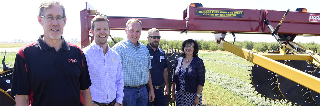 Andrew Cummings and family and Ag One staff and board members with new campus farm donation (alfafa rake)