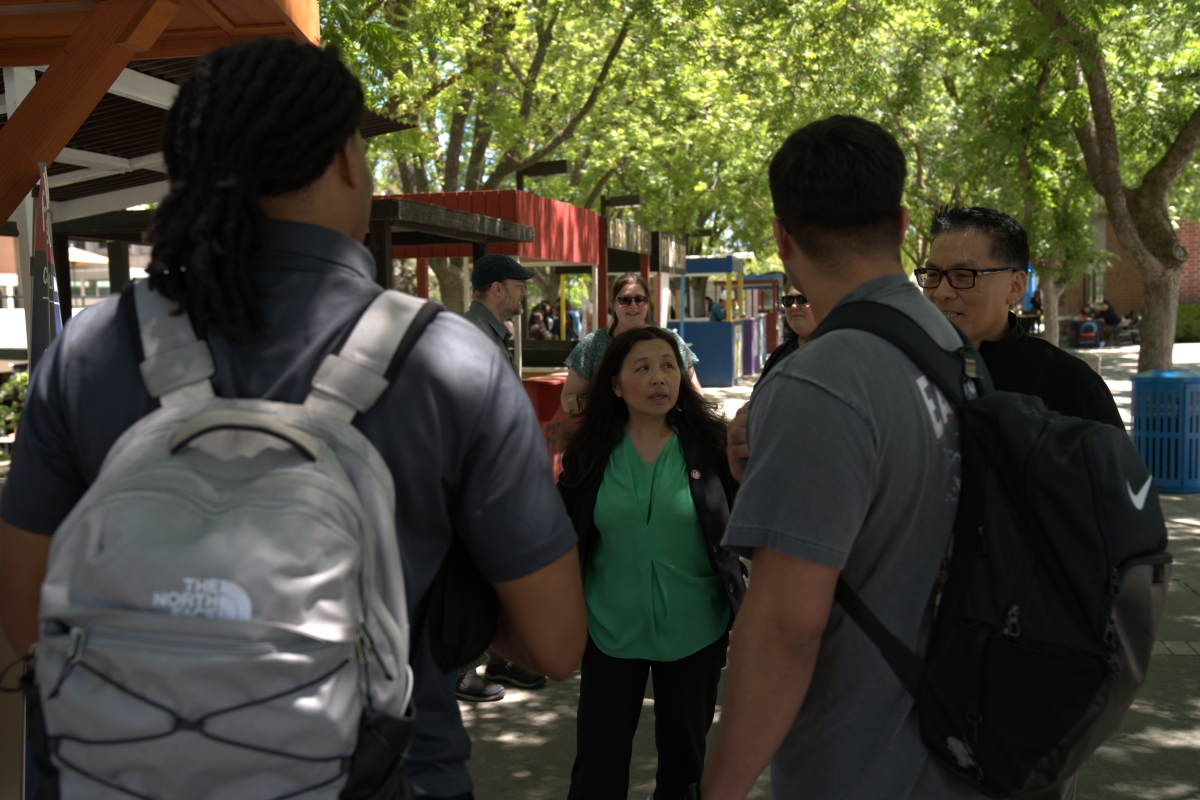 Photograph of Bao and Max engaging with students at the presidents booth