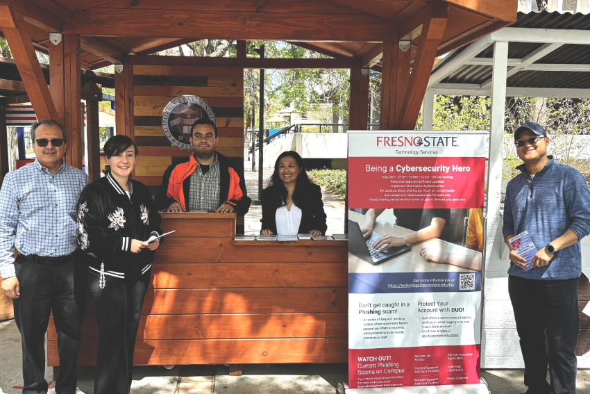 Bao and some cybersecurity student assistant as well as staff infront of the presidents booth