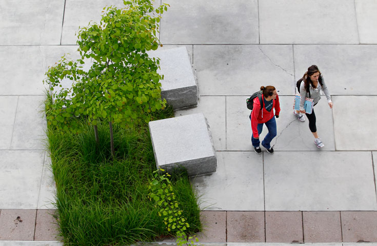 looking down at two students standing outside the library